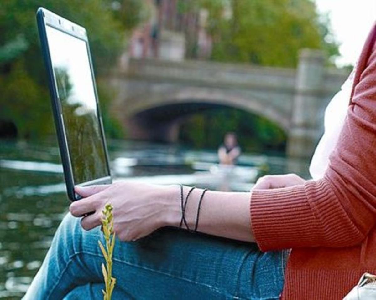 Una noia envia correus electrònics des del seu ordinador.