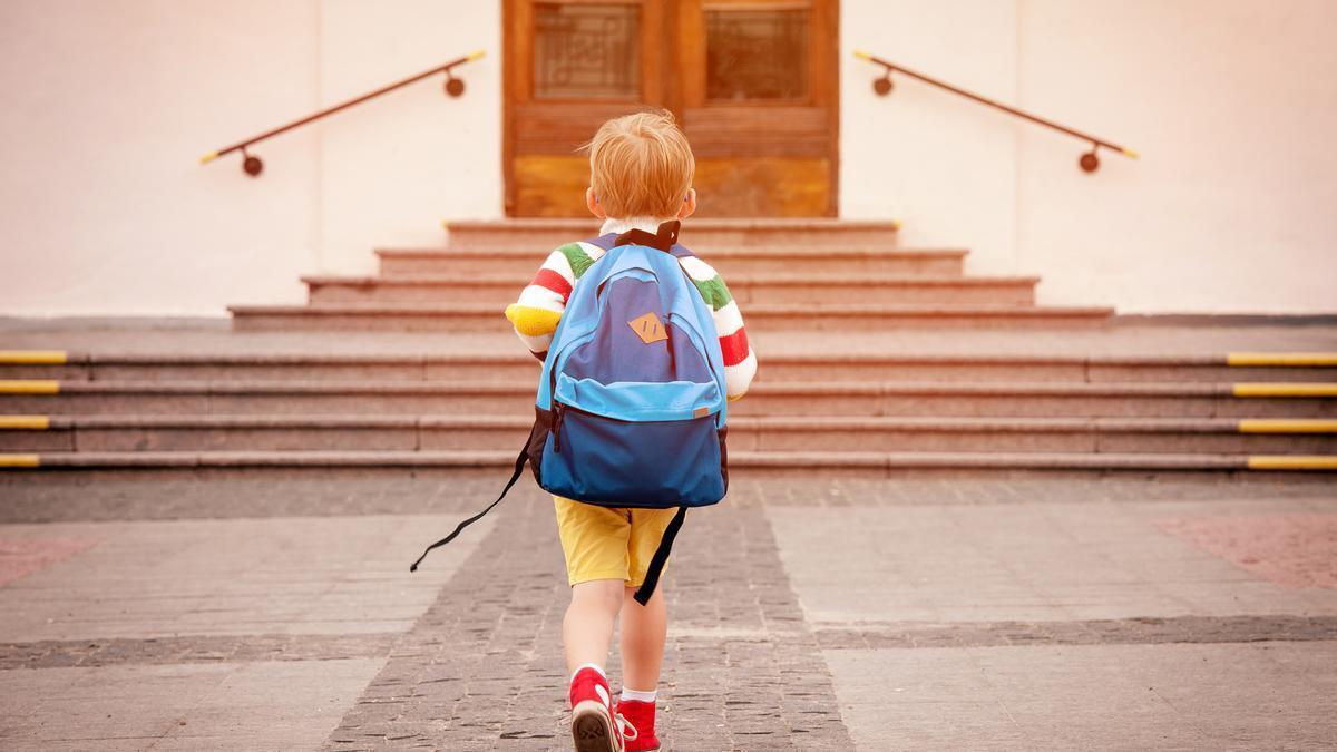 Un niño se dirige a su colegio cargando con su mochila.