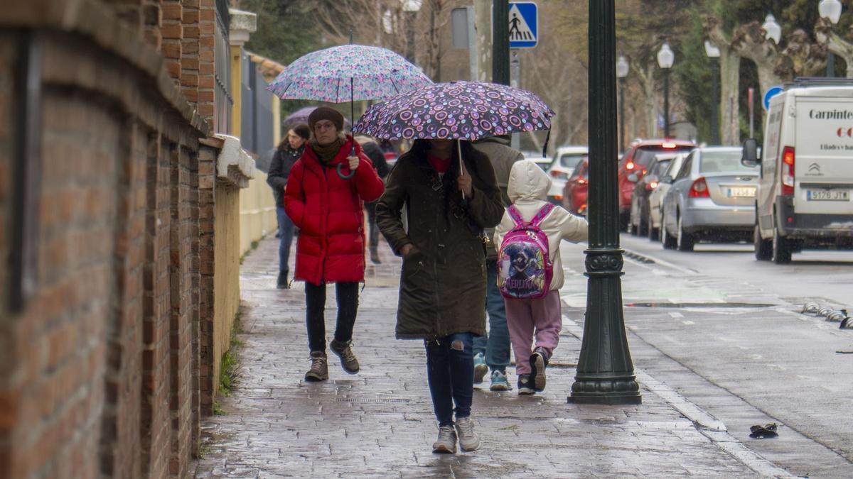 Varias personas caminan bajo la lluvia en Teruel.