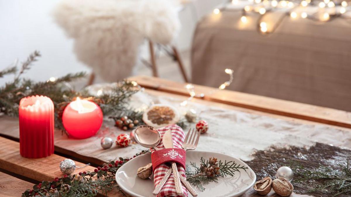 Una taula vestida amb branques d’avet, pinyes i espelmes | FREEPIK.COM