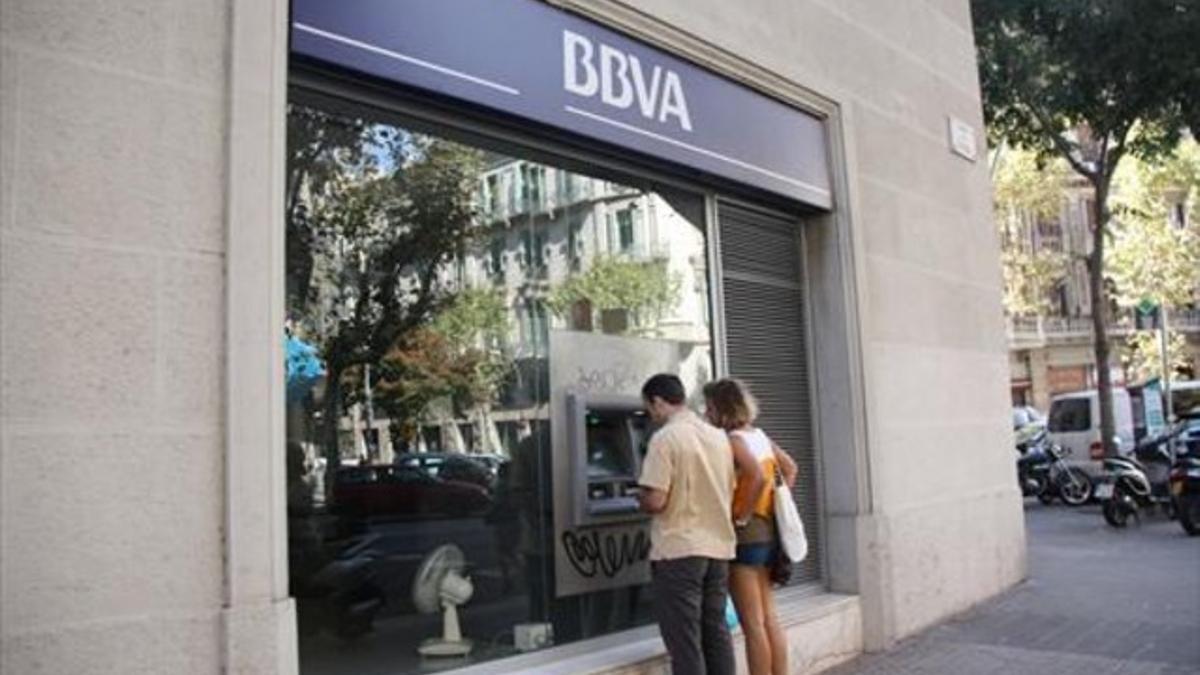 Dos clientes frente a un cajero del BBVA.