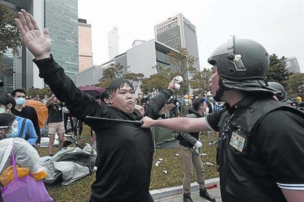 Un manifestant bloqueja el pas a un policia a Hong Kong, ahir.