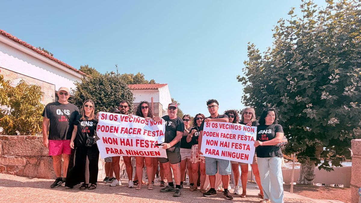 Vecinos de Ons, el domingo, con las pancartas en protesta por la prohibición de las fiestas.