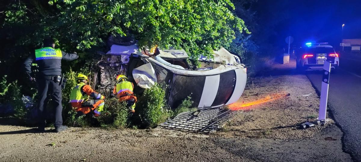 Bomberos, Policía Local y Sanitarios atendiendo al herido tras el choque en Oliva