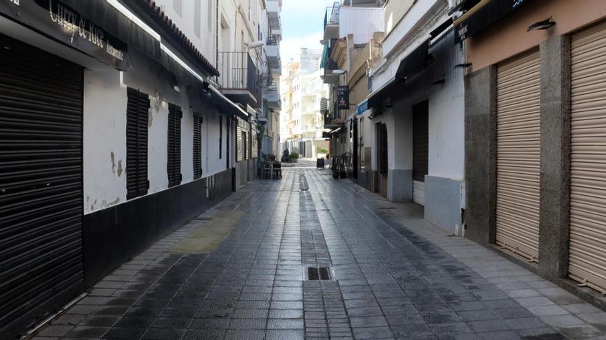Un carrer de Sitges amb persianes de bars i restaurants abaixades