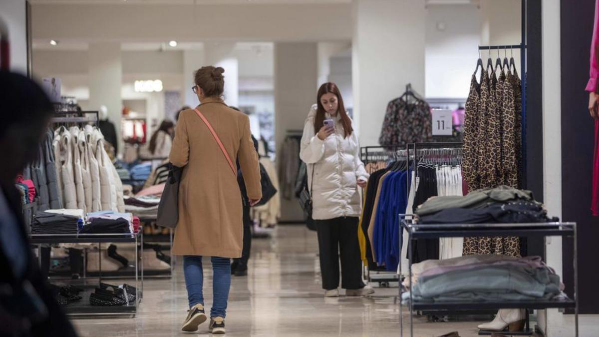 Clientas echando un vistazo a la ropa, por la tarde.