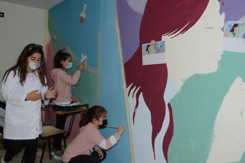 Varias niñas realizando el mural con el boceto de Sheela Tato delante.   | GONZALO NÚÑEZ