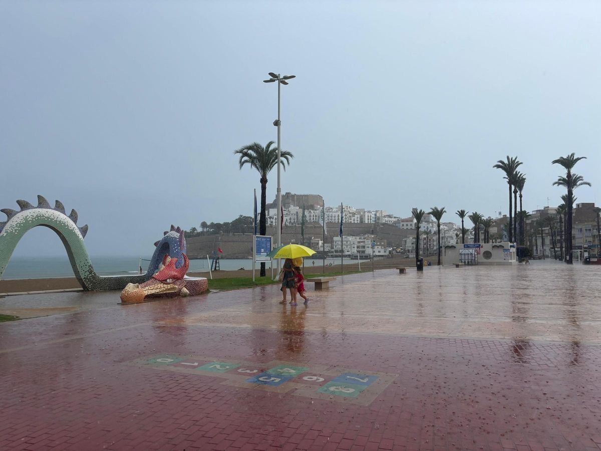 Gente con paraguas en el paseo de Peñíscola.