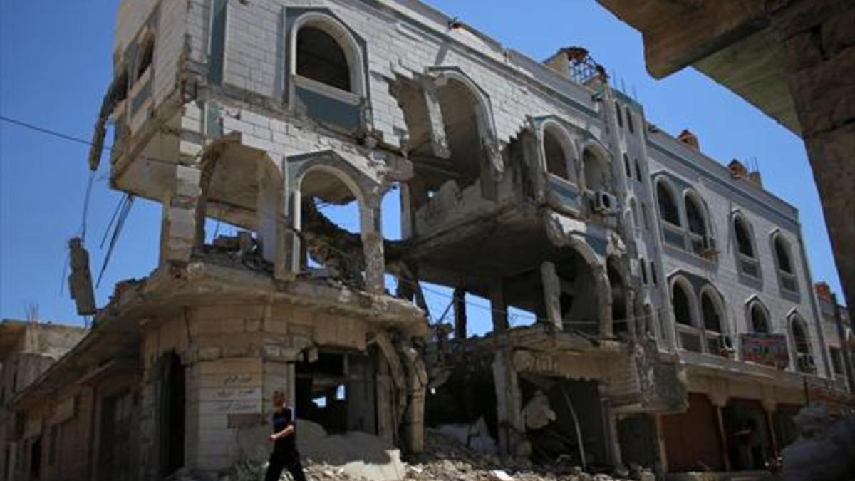 Un hombre camina ayer entre edificios destruidos de Inkhil, en manos de los rebeldes, en el sudoeste de Siria.