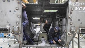 Trabajadores de Santa Bárbara, en la barcaza de un Dragón 8X8 en la factoría de Trubia (Asturias).
