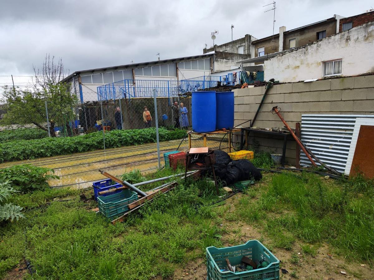 Vecinos de El Mohino, en la parte trasera de sus casas, ya anegada.