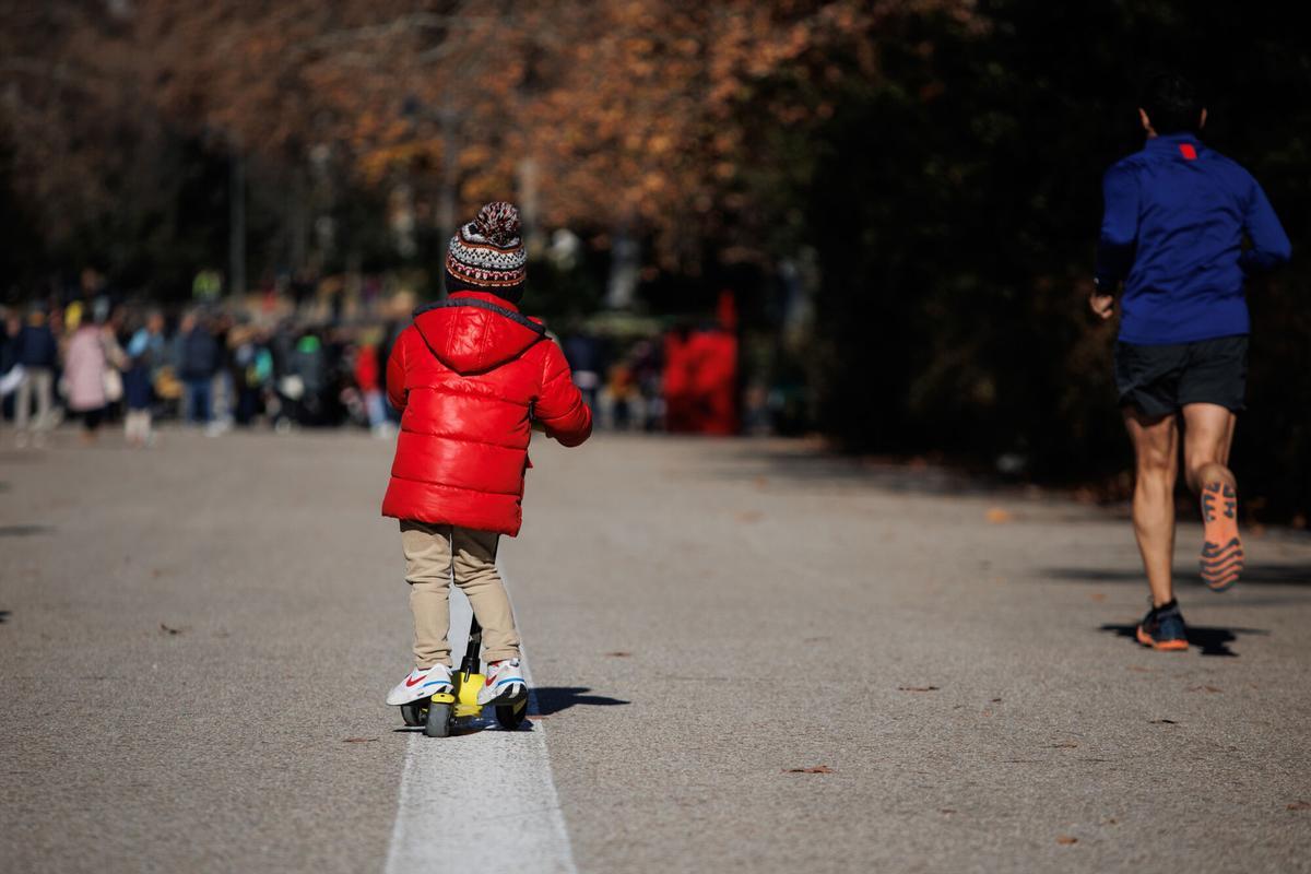 Niño encima de un patinete.