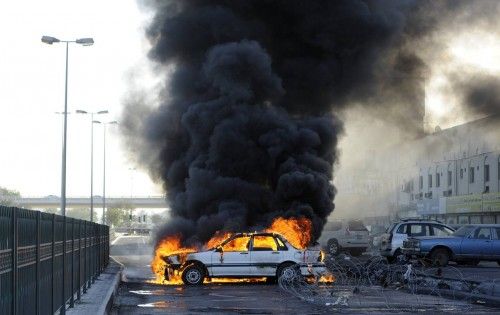 Manifestantes anti-gobierno prenden fuego a un coche para crear una barricada como celebración del segundo aniversario del levantamiento del 14 de febrero en Budaiya, Manama