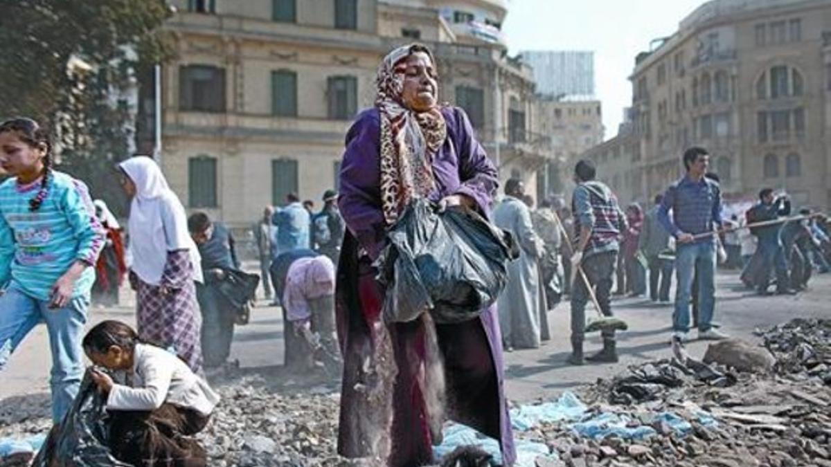 Limpieza masiva 8 Voluntarios recogen basuras y piedras delante del Museo Egipcio, junto a la plaza Tahrir, ayer.