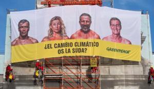 ¿El cambio climático os la suda? El lema de la lona que Greenpeace ha colgado en la Puerta de Alcalá
