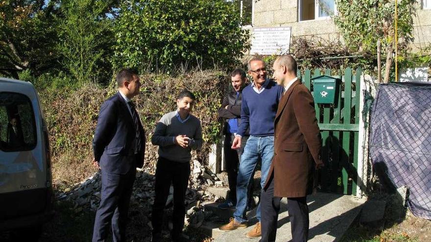 El alcalde y representantes del centro Juan María y de La Caixa, ante la vivienda municipal en obras.