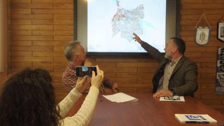 El concejal de Urbanismo y el alcalde revisan un plano con previsiones urbanísticas del municipio.