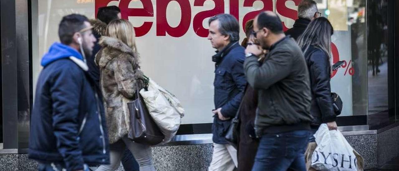 Varios ciudadanos, tras las primeras compras en las rebajas, en Oviedo.