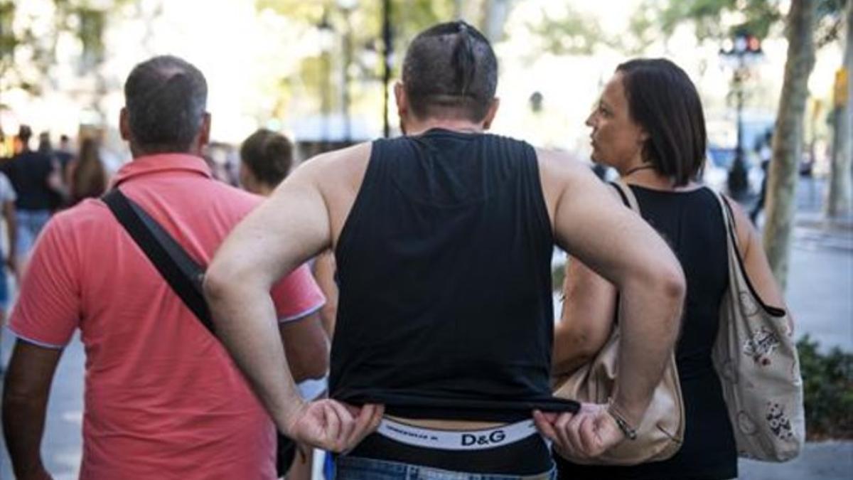 Un hombre con camiseta sin mangas y pantalones caídos, que dejan a la vista sus calzoncillos.