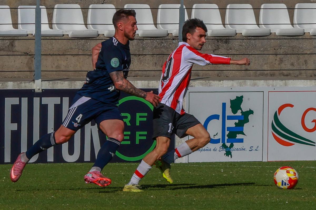 Julio Rey, con la camiseta del centenario del Céltiga, es perseguido por Adrián Cruz en un lance del encuentro.