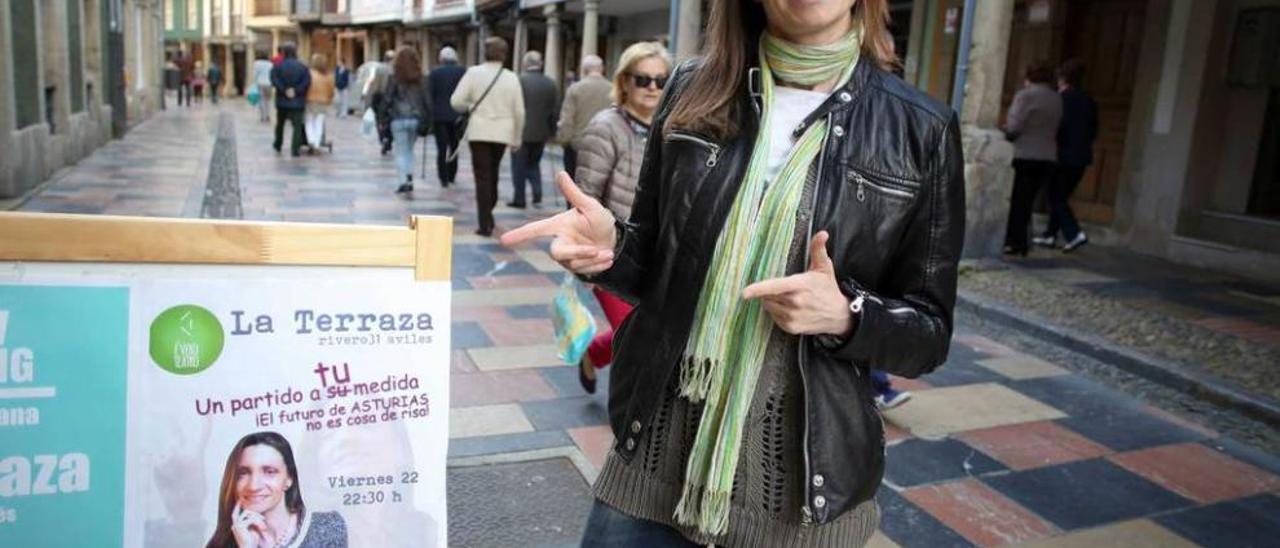 Verónica Gutiérrez posa junto al cartel &quot;electoral&quot; que anuncia su obra, ayer, en Avilés.