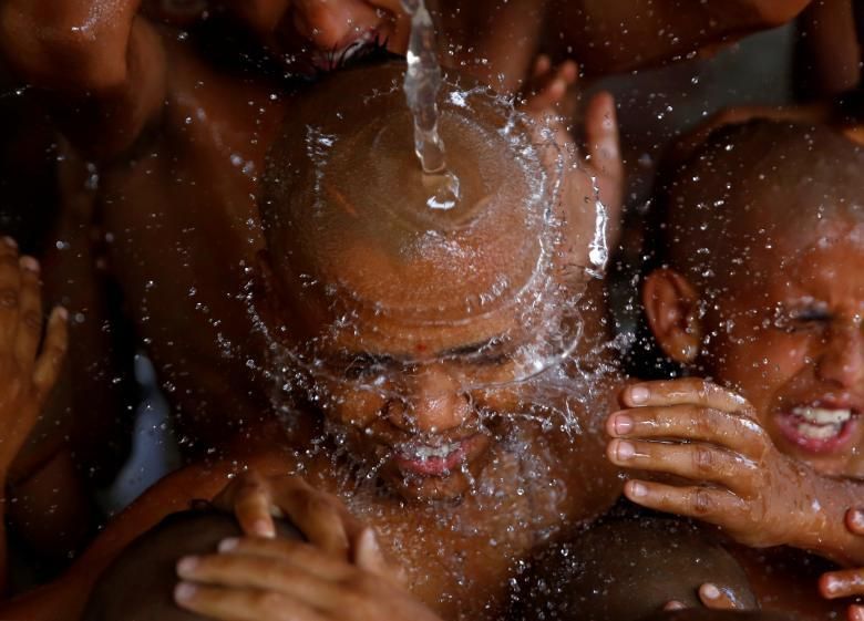 Els joves sacerdots hindús prenen un bany sagrat junts com a part d'un ritual durant el festival de fils sagrats al temple de Pashupatinath a Kathmandu, Nepal el 28 de juliol.