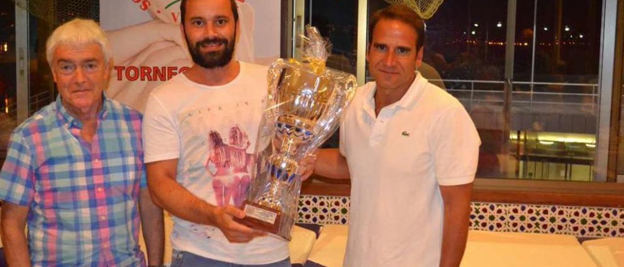 Manel Fernández, concejal de Deportes (izquierda) y Fernando Viso, director del centro médico O Castro, patrocinador del torneo, entregan el trofeo de campeón de liga a Santi, delegado del club Anca.