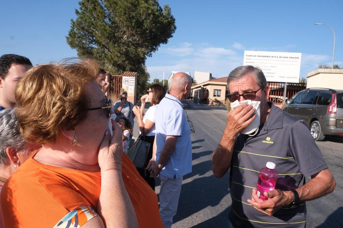 Vecinos afectados se tapan la nariz en una cita colectiva a las puertas de la planta de tratamiento de residuos sólidos de Els Cremats en Elche.