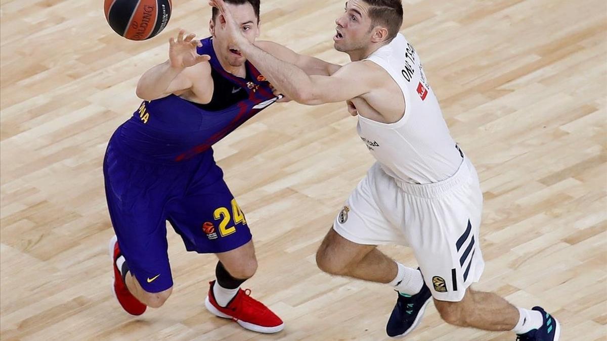 El azulgrana Kuric pelea por un balón con el madridista Causeur