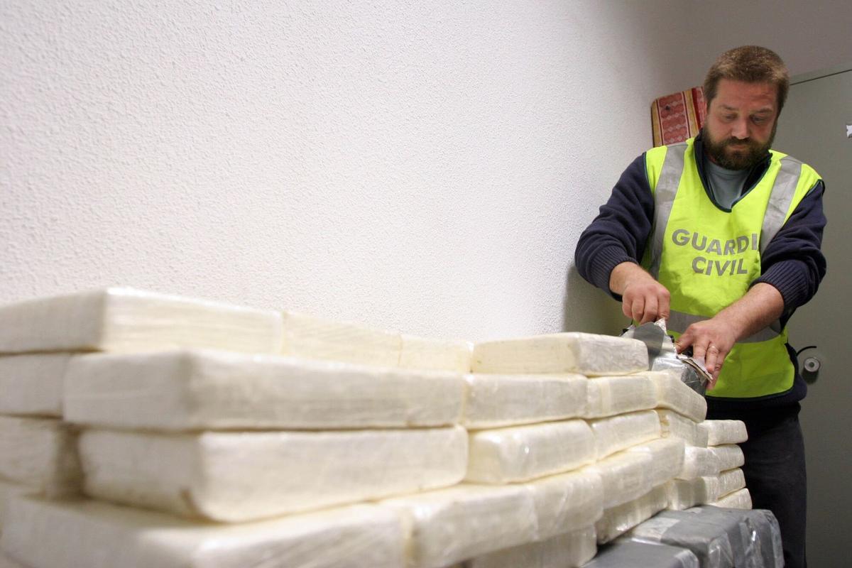 ALG01. ALGECIRAS (CÁDIZ), 25/04/07.- Un agente de la Guardia Civil muestra uno de los fardos que albergaban los 277 kilogramos de cocaína confiscados hoy en el puerto andaluz de Algeciras, que venían ocultos entre palés que contenían envases de pimentón, en el interior de un contenedor procedente del puerto peruano del Callao. EFE/A.Carrasco Ragel