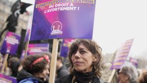 Una mujer muestra un cartel reclamando la inclusión en la Constitución del derecho al aborto, durante la manifestación del pasado 8 de marzo en París.