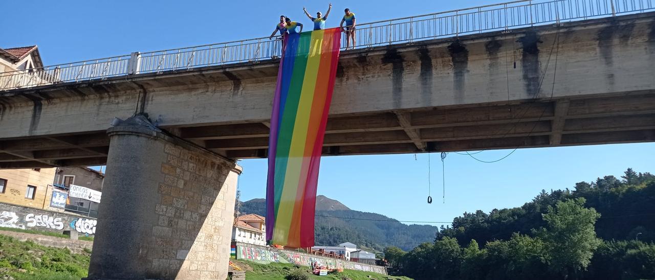 La bandera, colgando sobre el puente, ayer, con varios participantes en la prueba en el río. | J. Quince