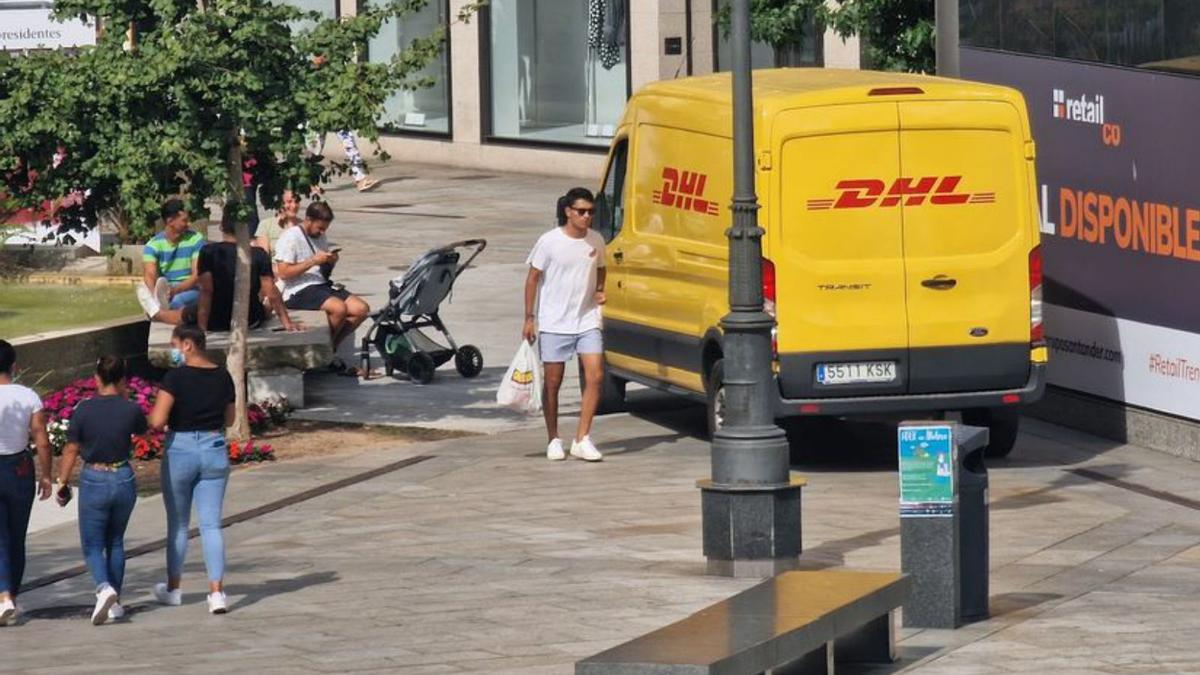 Una furgoneta de reparto se abre camino entre los peatones de la plaza de Galicia. |   //  M.M.