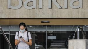 Una mujer sale de la sede de Bankia en Valencia