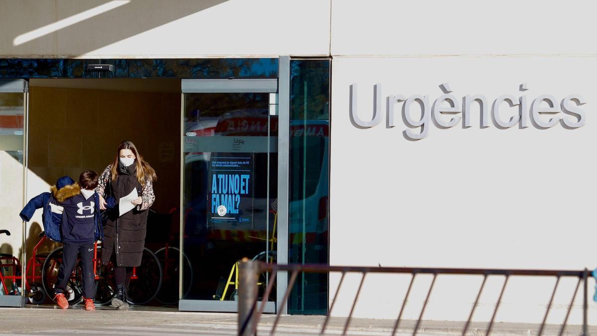 Un par de personas salen del hospital La Fe con la mascarilla en enero de 2024.