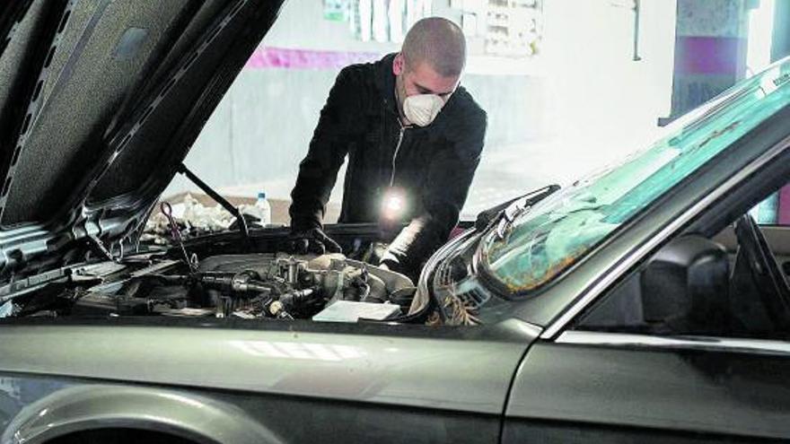 Un mecánico autónomo trabaja en la reparación de un coche en su taller de Santa Cruz de Tenerife.