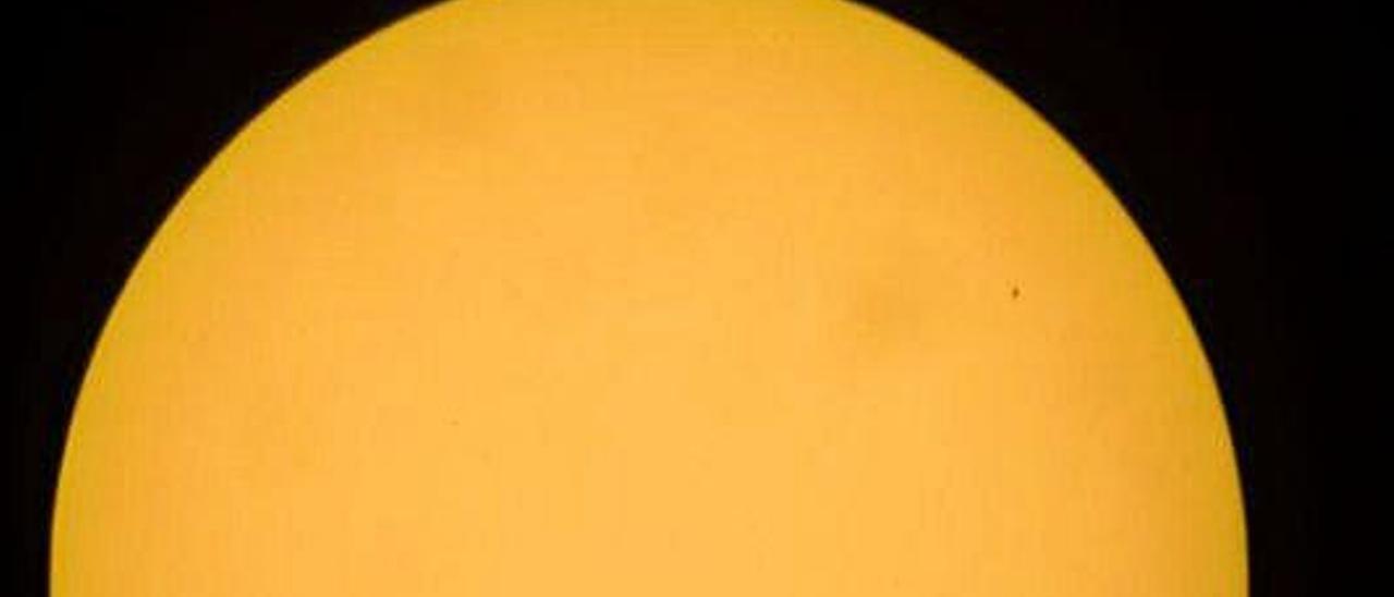 Mercurio, arriba a la derecha, durante su tránsito por delante del Sol.