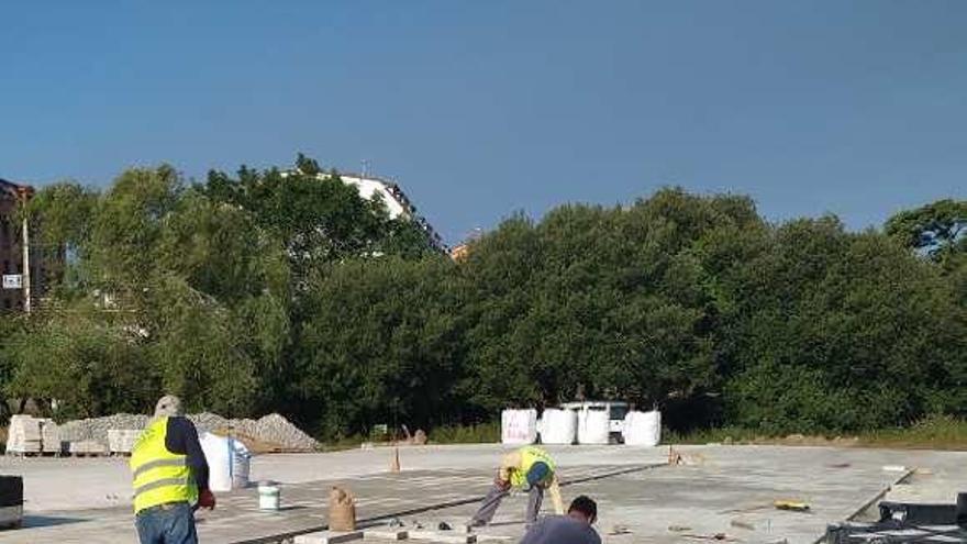 Obras de empedrado de la plaza pública de Dena. // Faro