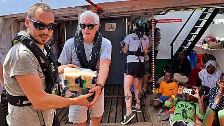 El actor Richard Gere ayuda a introducir víveres en el barco.