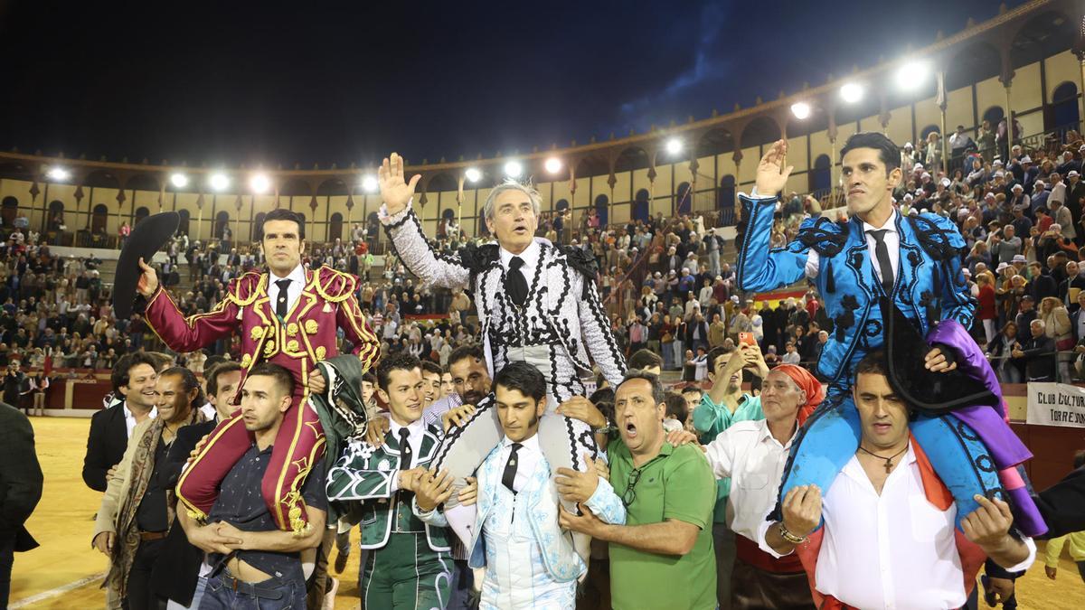 Los diestros Alejandro Talavante (d), Emilio de Justo (c) y Luis Reina (i), salen a hombros tras la corrida goyesca que se ha celebrado hoy sábado en la plaza de toros de Almendralejo, lidiando reses de Juan Pedro Domecq