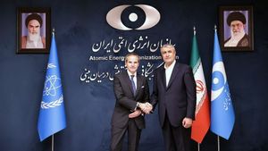 El director general de la Organización Internacional de la Energía Atómica, Rafael Grossi, saluda al jefe de la Organización de la Energía Atómica de Irán, Mohammad Eslami, antes de su reunión este jueves en Teherán.