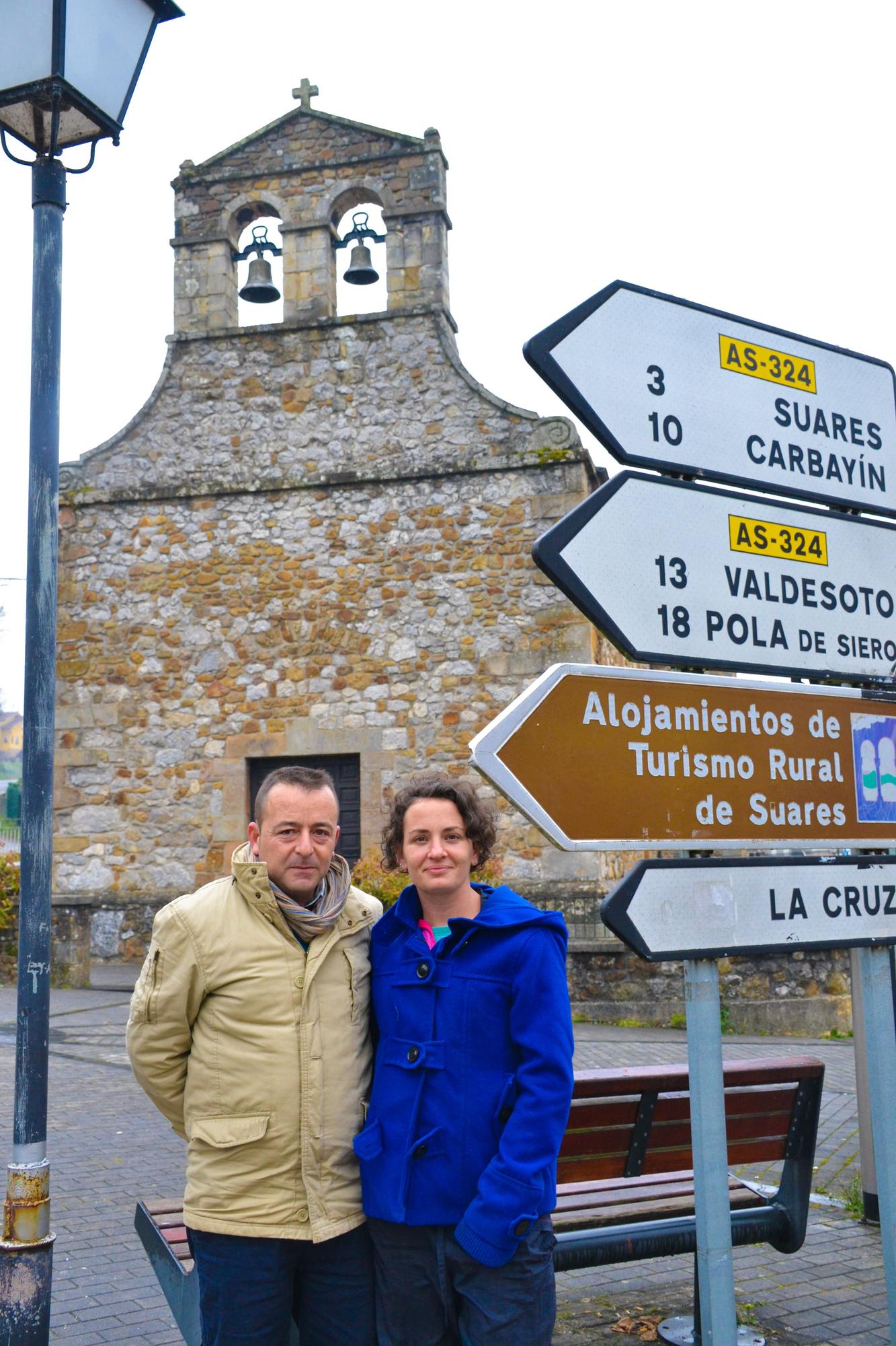 Diego Caturla y Paloma de Pablos, posan delante de la iglesia de San Julián de Bimenes.