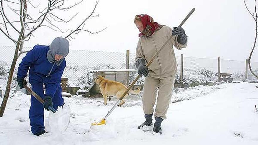 Una familia retira nieve en As Estivadas (Ourense).