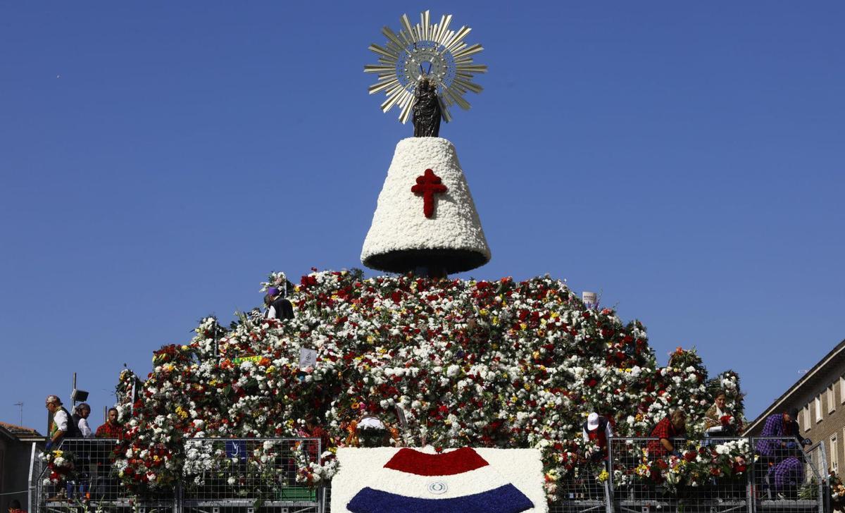 La Virgen del Pilar luce este año un manto de claveles blancos, rojos y azules, acompañado de más de siete millones de flores. |   