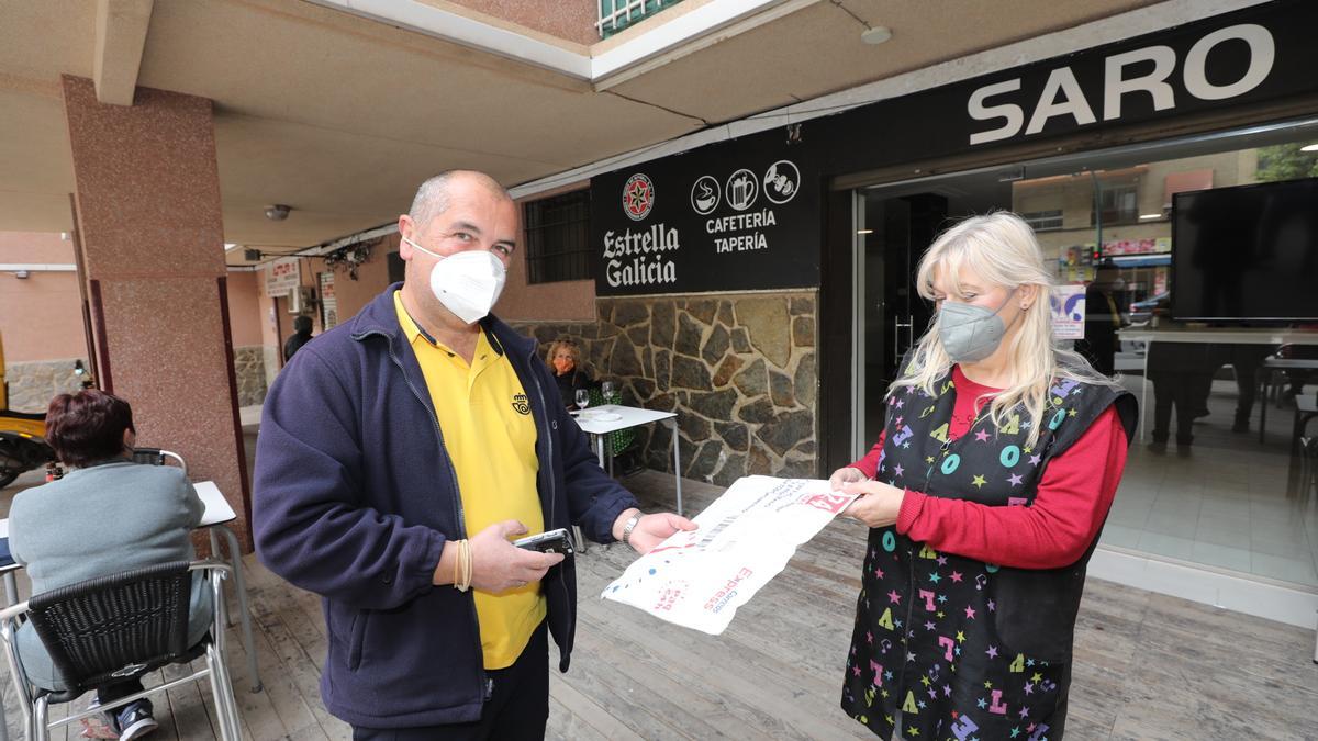 El cartero Gabriel Reig Ripoll entregando un envío a una de sus &quot;clientas&quot; del barrio Carrús de Elche.