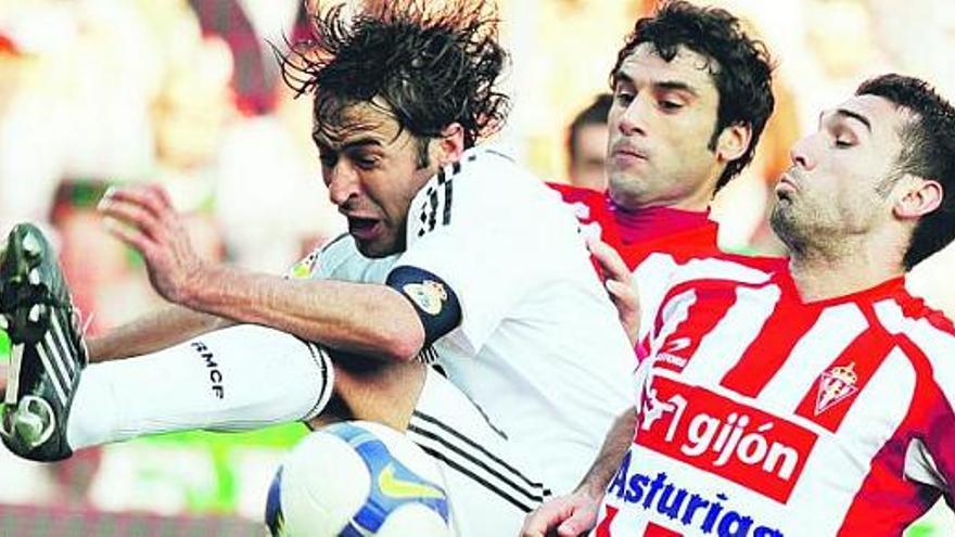 David Barral, a la derecha, lucha un balón con Raúl en presencia de Sastre.