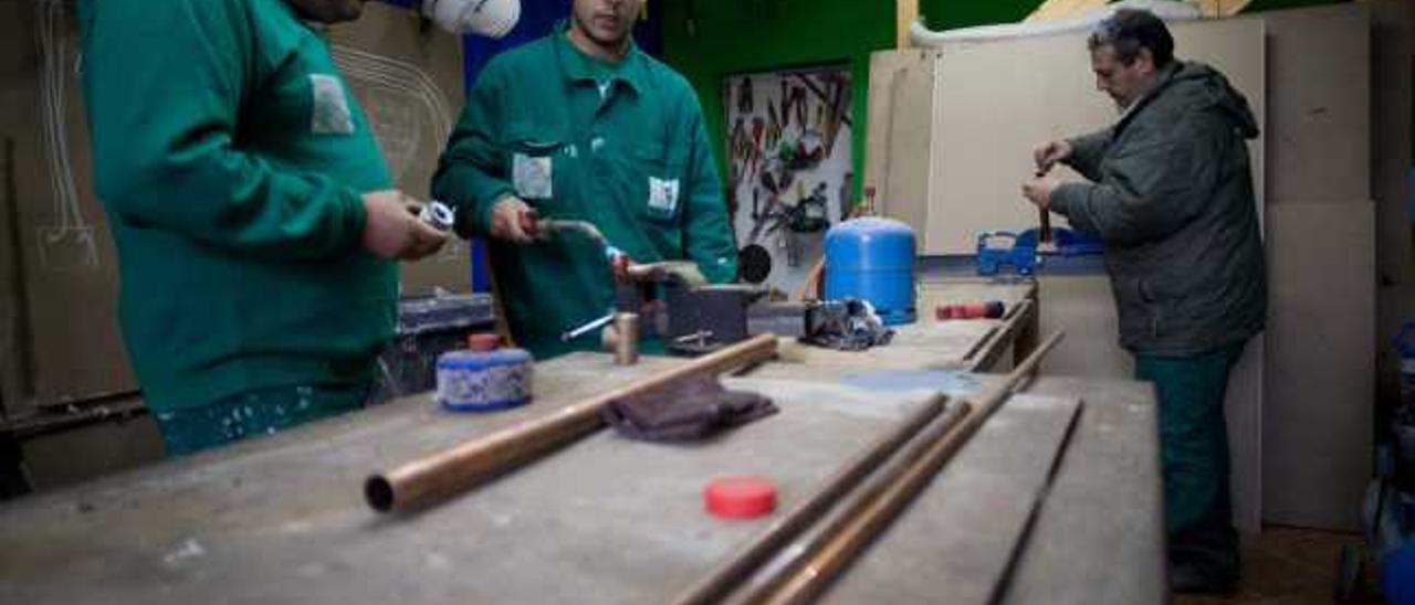 José Ramón Campa, Mario Artime y José Benjamín Campa, haciendo tareas de soldadura en el taller.