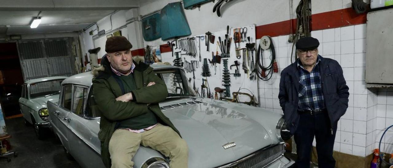 Rufino Acebal y su padre, que se llama como él, ayer, en su garaje, junto a uno de sus coches clásicos, un Opel Kapitán de 1962. | Juan Plaza