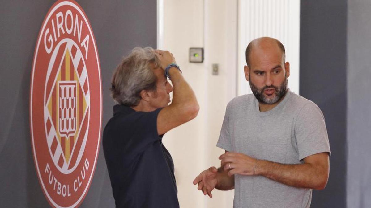 Guardiola conversa con el director de comunicación del Girona en las instalaciones del club.