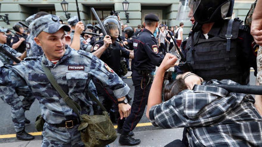 Un policía golpea a un manifestante en Moscú.